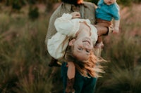 a man and his two children are holding each other in the grass