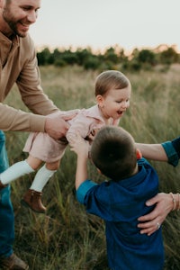 a family playing in a field at sunset